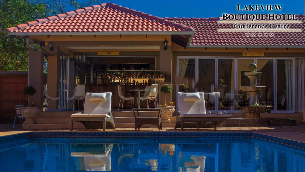 una piscina con sillas y un bar junto a una casa en Lakeview Boutique Hotel & Conference Center en Benoni