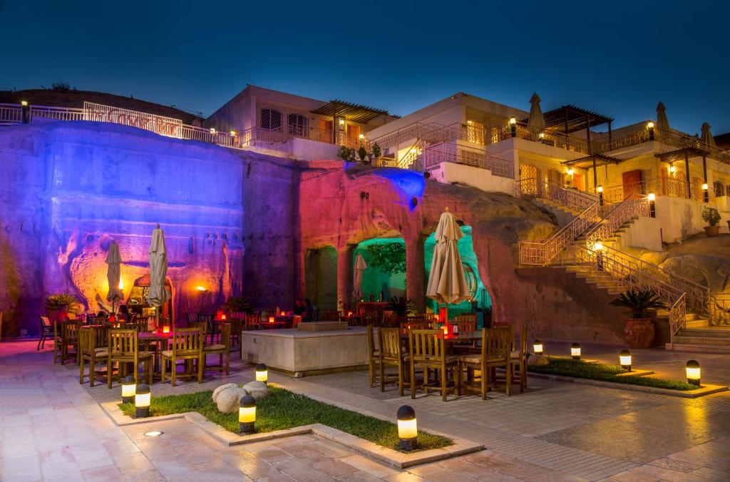 a patio with tables and umbrellas at night at Petra Guest House Hotel in Wadi Musa