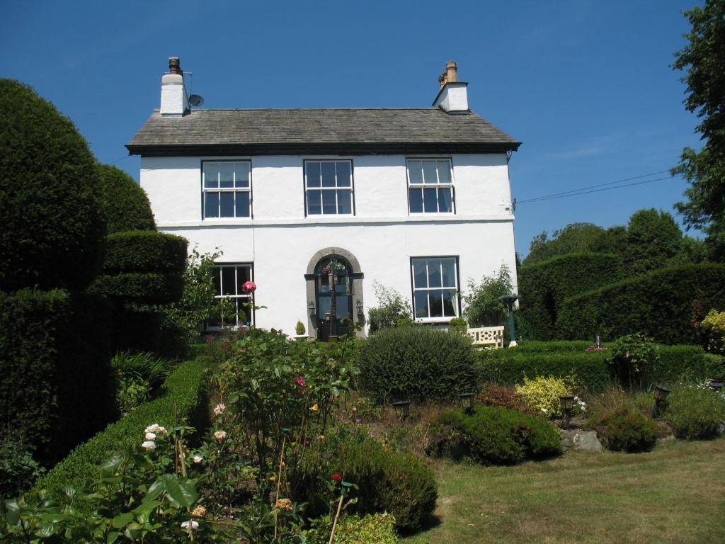 Biały dom z ogrodem przed nim w obiekcie The Hill w mieście Windermere