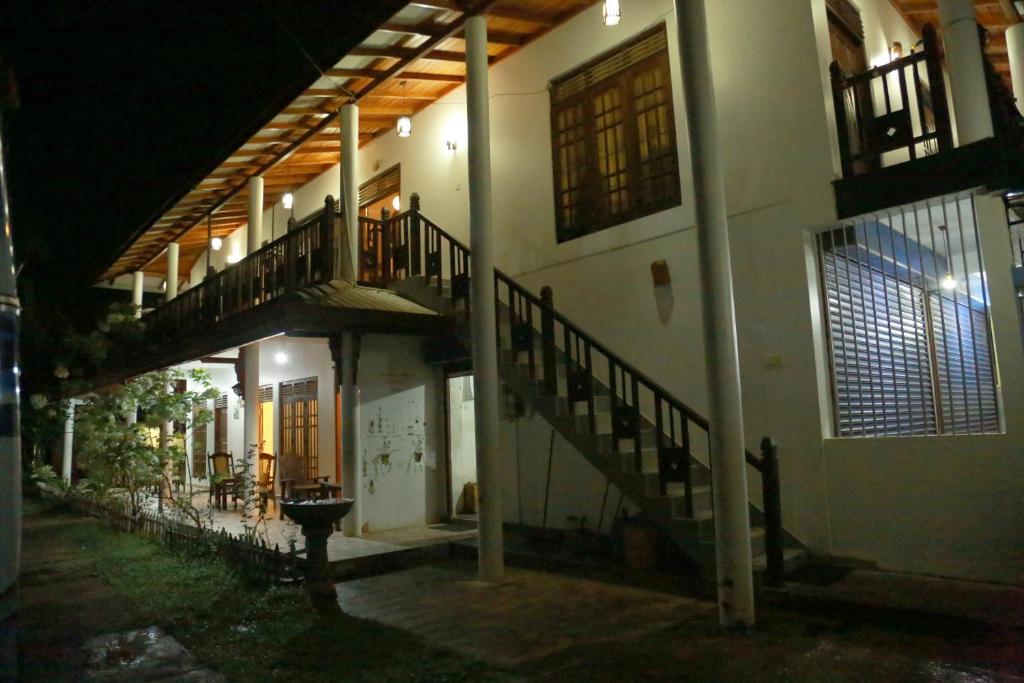 a building with stairs on the side of it at night at Omee Guest in Mirissa