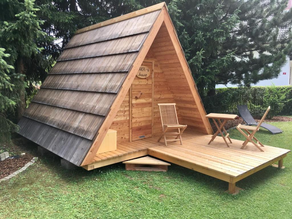 Cabaña de madera pequeña con 2 sillas y mesa en Glamping houses J-Max en Bled