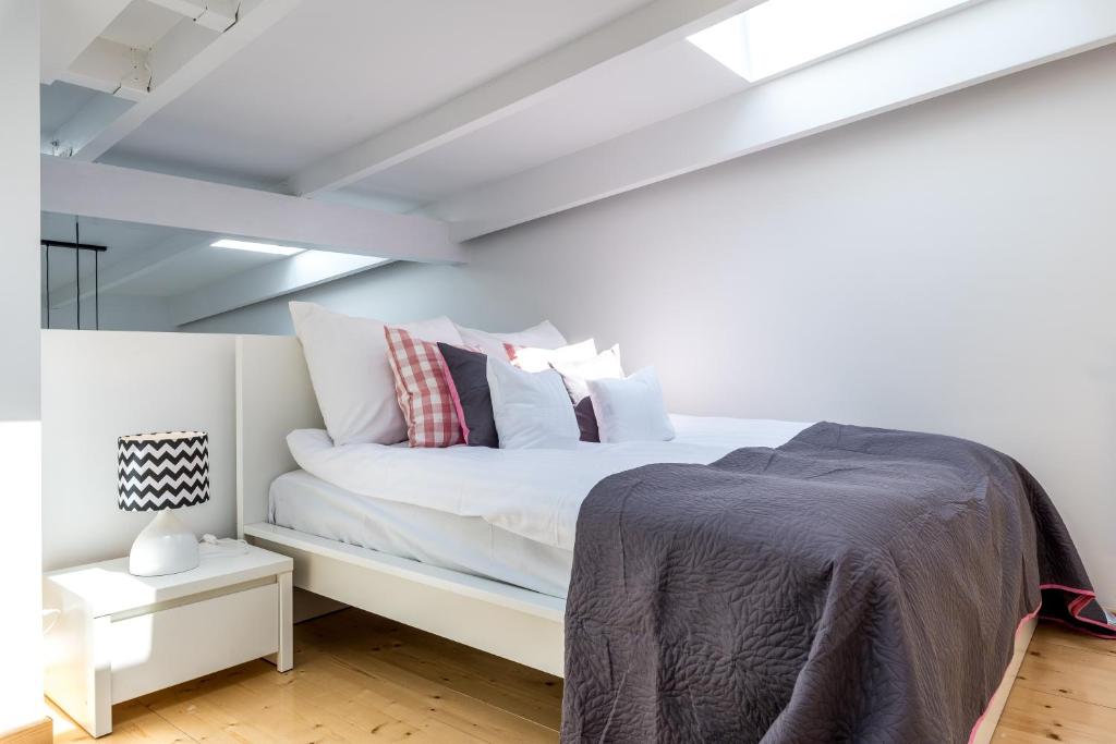 a bedroom with a white bed with pillows on it at Panorama Twin Loft Superior in Poznań