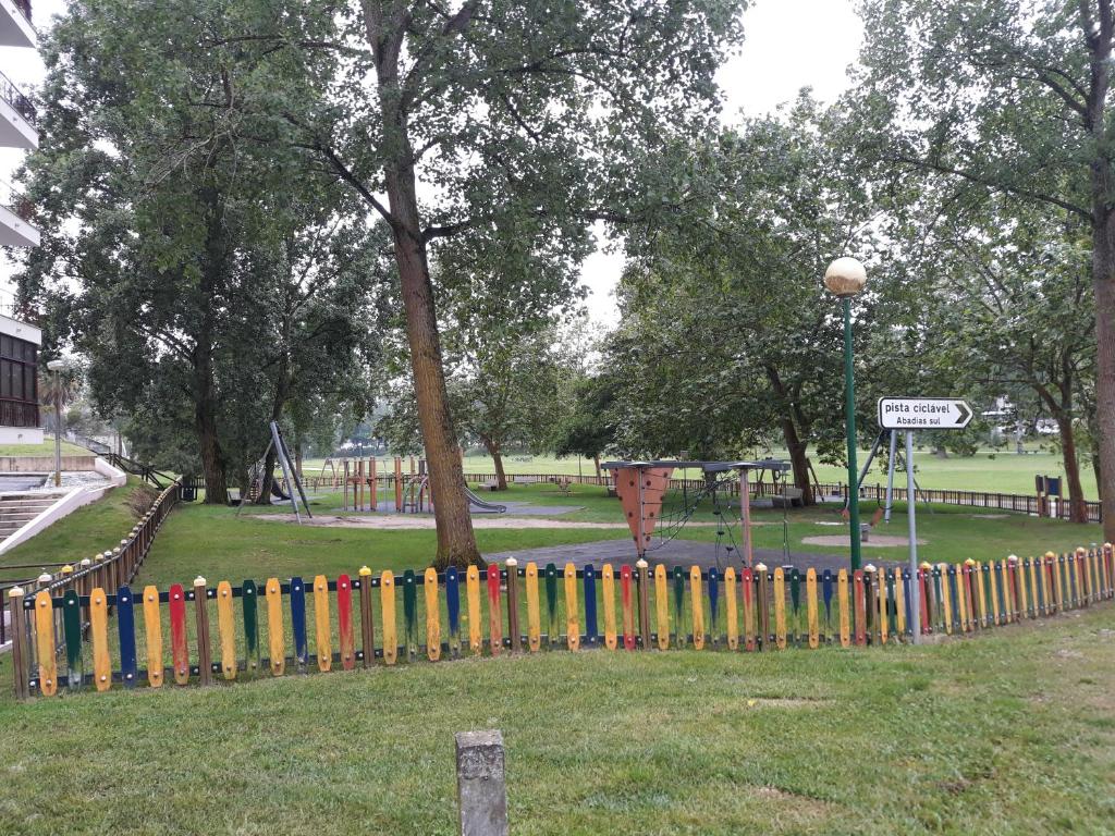 a colorful fence in a park with a playground at Âncora da Foz in Figueira da Foz