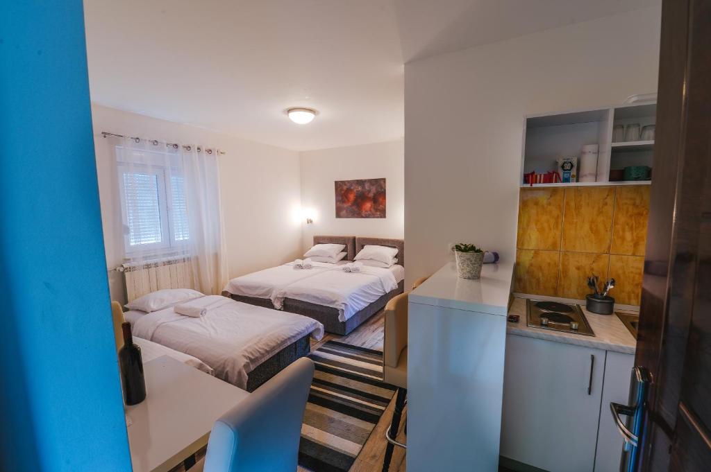 une petite chambre avec deux lits et une cuisine dans l'établissement Villa Marija, à Trebinje