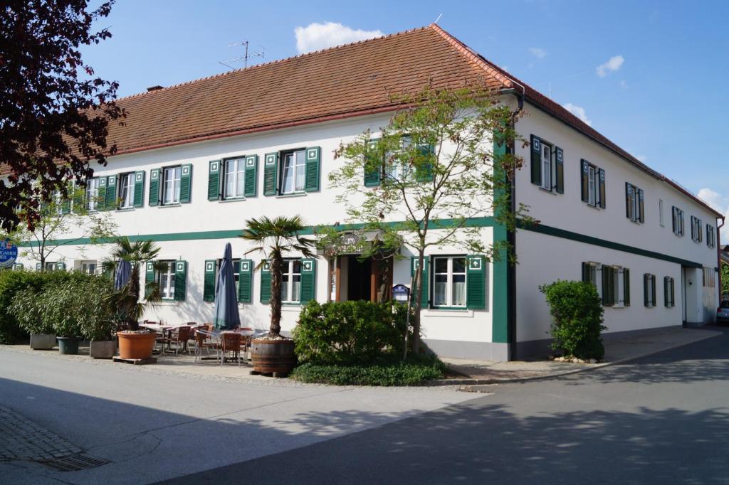 a large white building with green trim on a street at Gasthof zum Hirschen in Burgau