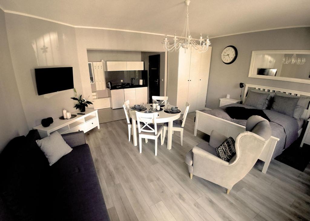 a living room with a table and a dining room at Apartamenty Aleksandria in Kamień Pomorski