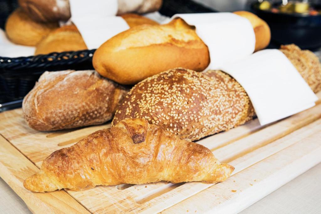 a group of breads and pastries on a cutting board at Hotel Internazionale Bellinzona in Bellinzona