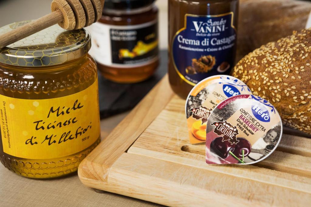 a jar of mustard on a cutting board with bread at Hotel Internazionale Bellinzona in Bellinzona