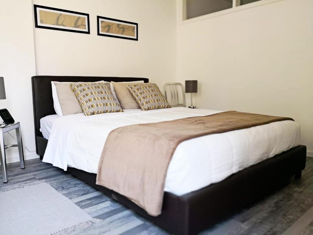 um quarto com uma cama grande com lençóis brancos e almofadas em Cheerful Apartment in Nicosia em Yukarı Lakatamya