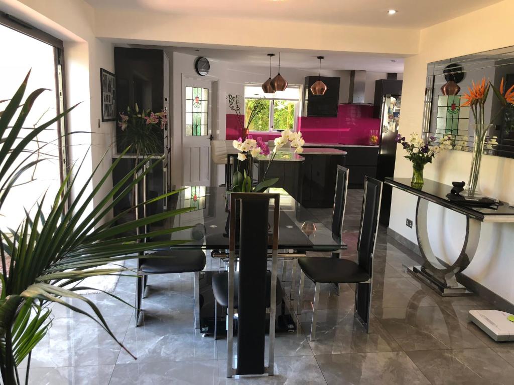 a dining room with a glass table and chairs at Hadrian House in East Preston