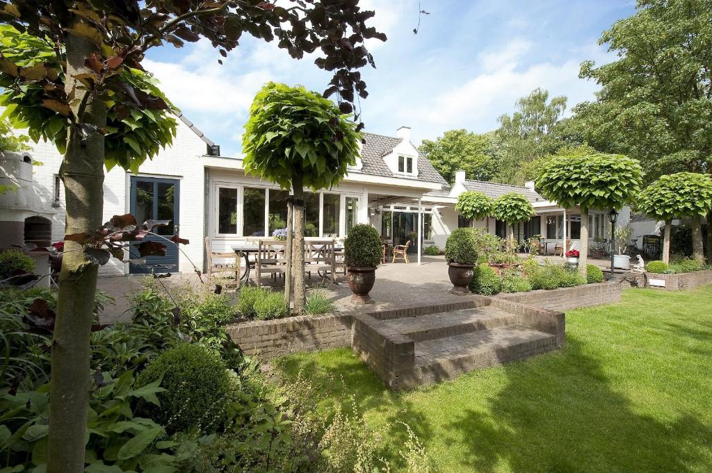 ein Haus mit einem Garten und einer Terrasse in der Unterkunft Bed and Breakfast Het Dijkhuis Eersel in Eersel