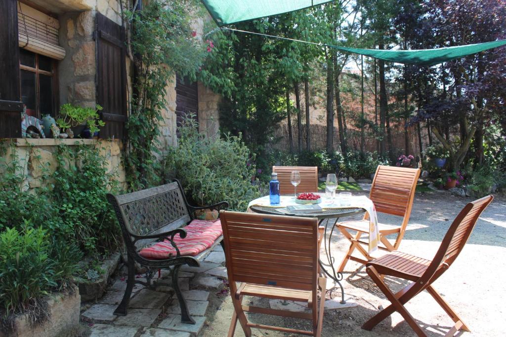 een patio met een tafel en stoelen in een tuin bij Ca la Nuri in Senant