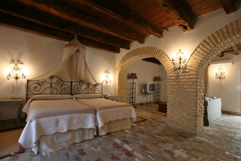 a bedroom with a large bed with an archway at Posada de Palacio in Sanlúcar de Barrameda