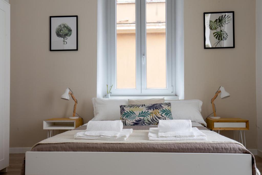 ローマにあるA+ Bed and Breakfastのベッドルーム1室(ベッド1台、テーブル2台、窓付)