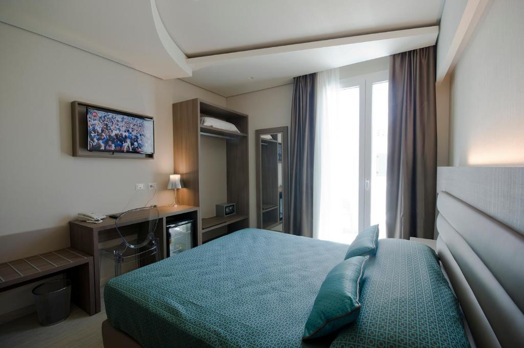 a hotel room with a bed and a television at Hermes Hotel in San Vito lo Capo