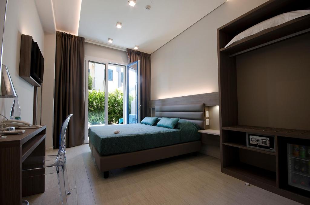 a bedroom with a bed and a large window at Hermes Hotel in San Vito lo Capo