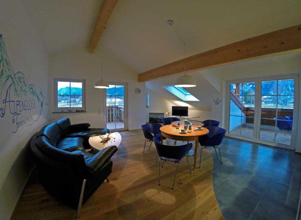 ein Wohnzimmer mit einem Sofa, einem Tisch und Stühlen in der Unterkunft Alpenglück de Luxe Ferienwohnung am Forggensee in Schwangau