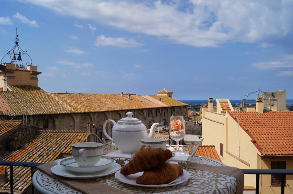a table with a plate of food on a balcony at Le torri di Tarquinia in Tarquinia