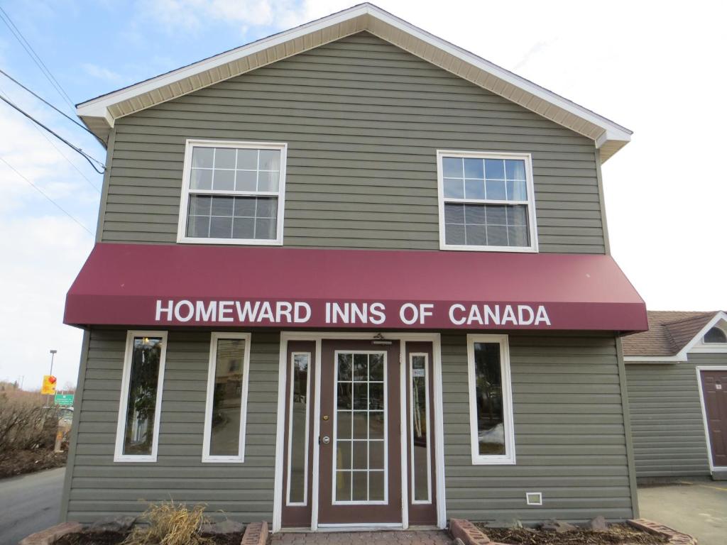 Uma casa com um cartaz que lê os membros do Canadá. em Homeward Inns of Canada em Antigonish