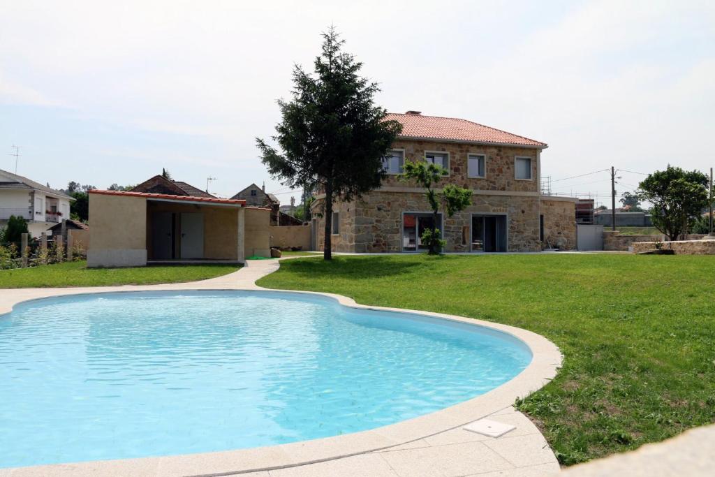uma piscina em frente a uma casa em A Finquiña em Pontevedra