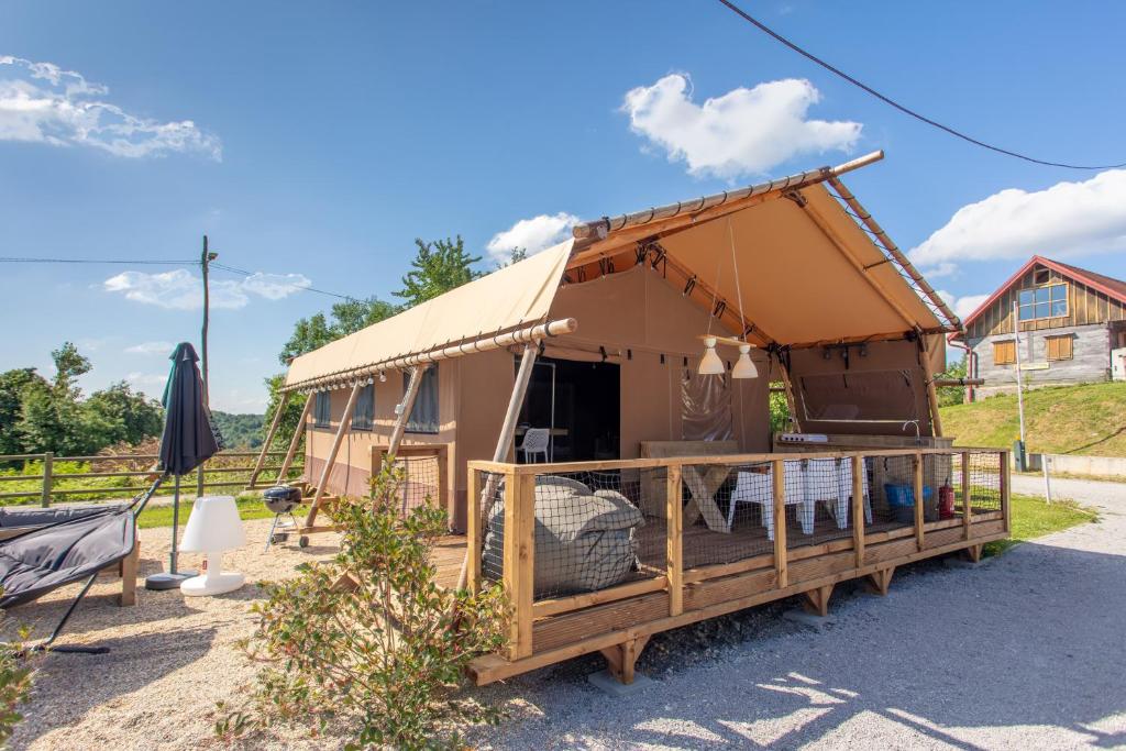 a large tent with a porch in a yard at Lodge Holidays - Glamping Heart of Nature in Ribnik
