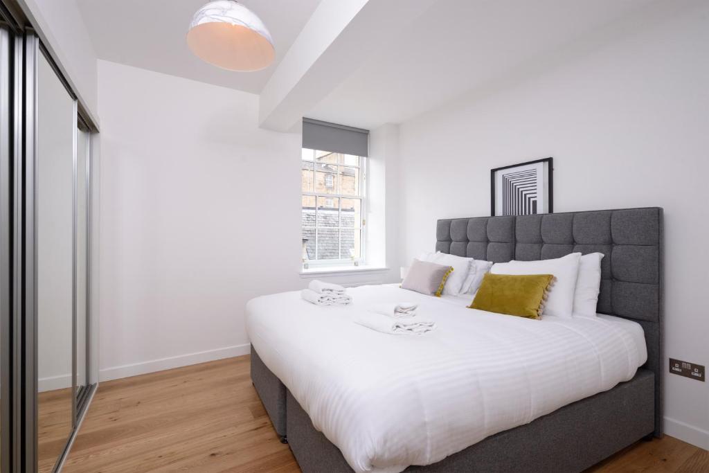 a bedroom with a large bed with white sheets at Destiny Scotland Apartments at Canning Street Lane in Edinburgh
