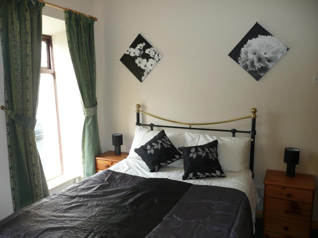um quarto com uma cama com duas almofadas e uma janela em Barron's Bed & Breakfast em Moville