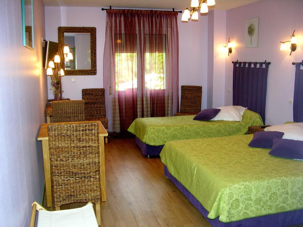 Habitación de hotel con 2 camas y espejo en Les Norias, en Cazilhac
