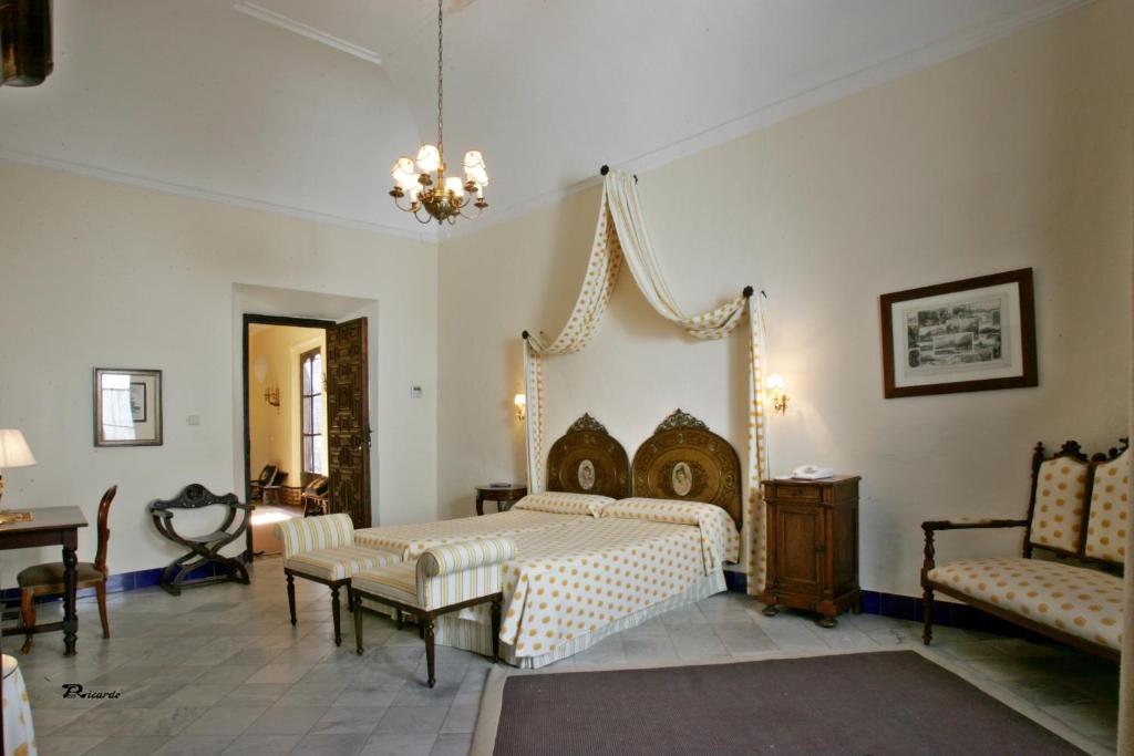 a bedroom with a bed and a table and chairs at Posada de Palacio in Sanlúcar de Barrameda