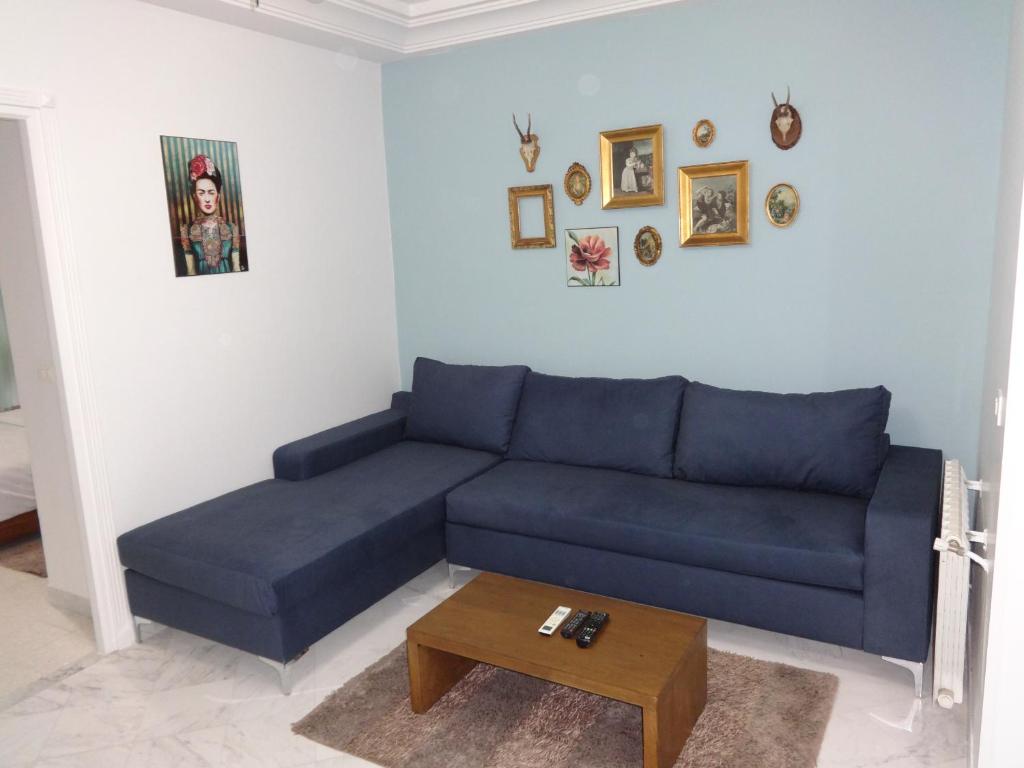 a blue couch in a living room with a table at Appartement Les Palmerais in El Aouina