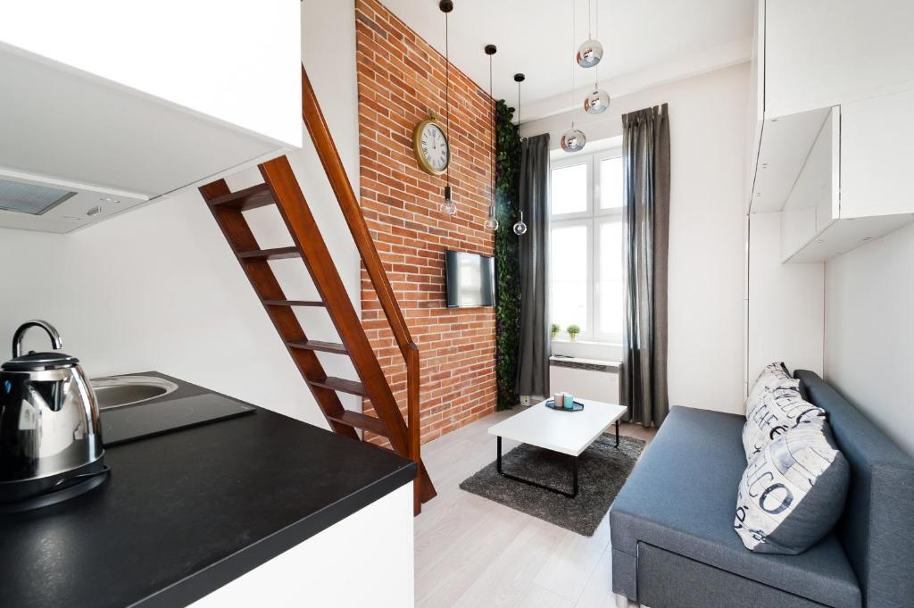 eine Küche und ein Wohnzimmer mit einer Ziegelwand in der Unterkunft Dietla 99 - Studio by Homeprime in Krakau