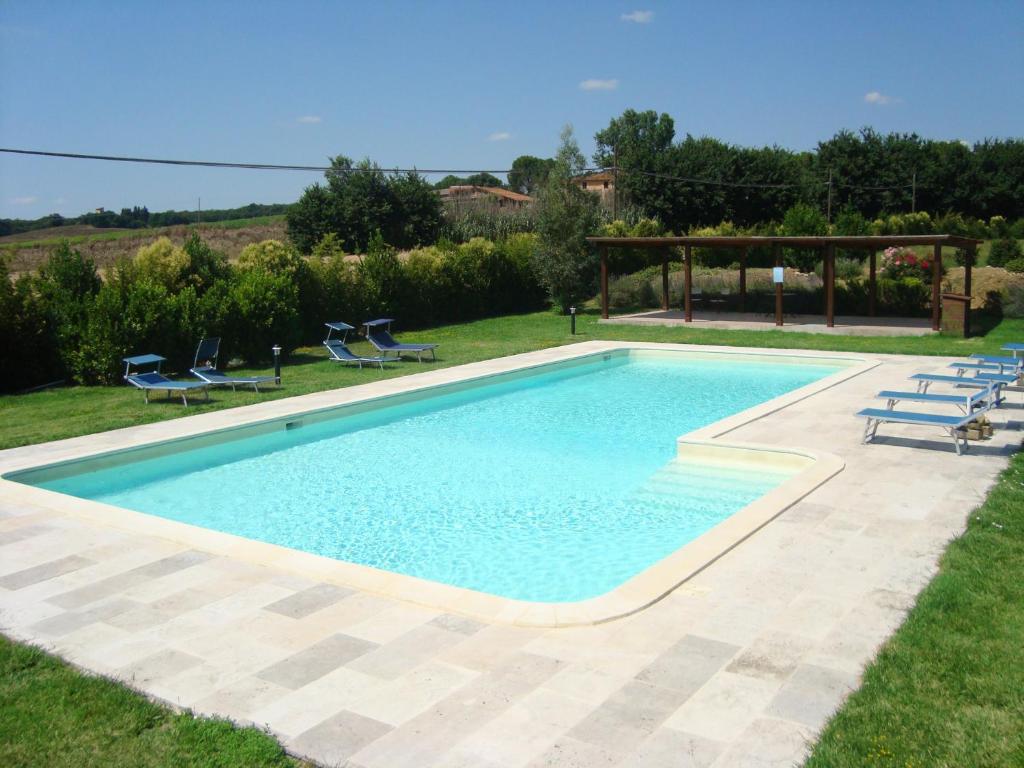 a swimming pool in a yard with chairs and a gazebo at Casa Grande in Perugia