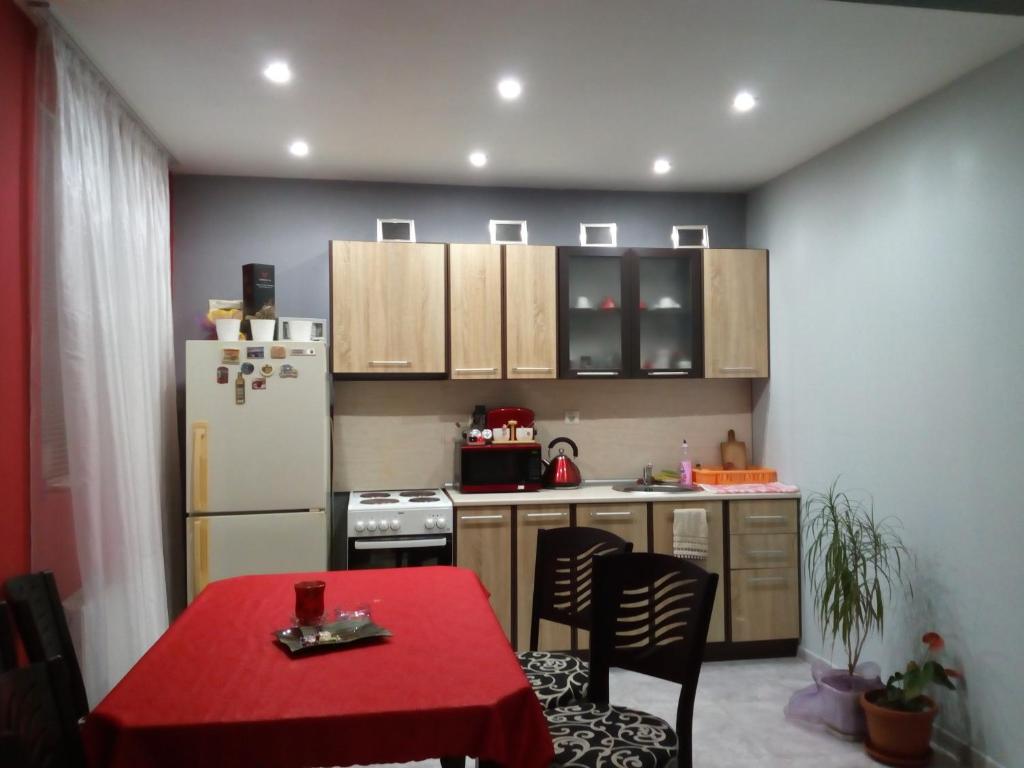 a kitchen with a red table and a refrigerator at Apartment Diana in Resilovo