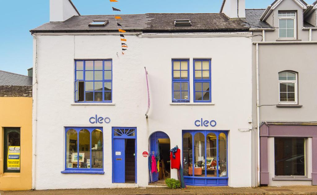 a white building with blue doors and windows at Cleo Gallery Apartments in Kenmare