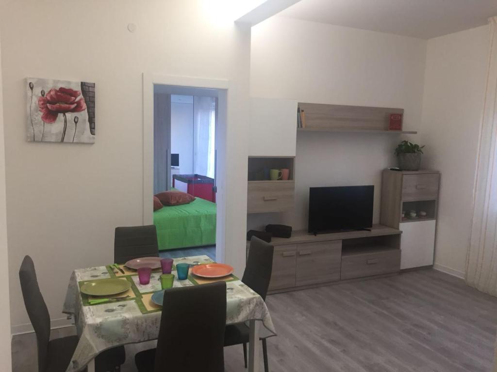 ein Wohnzimmer mit einem Esstisch und ein Schlafzimmer in der Unterkunft Casadolcecasa in Bologna