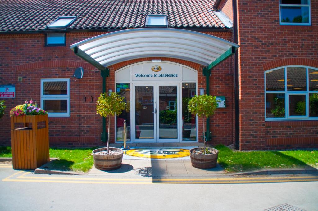 un edificio de ladrillo con una entrada con dos macetas en Stableside Hostel at York Racecourse, en York