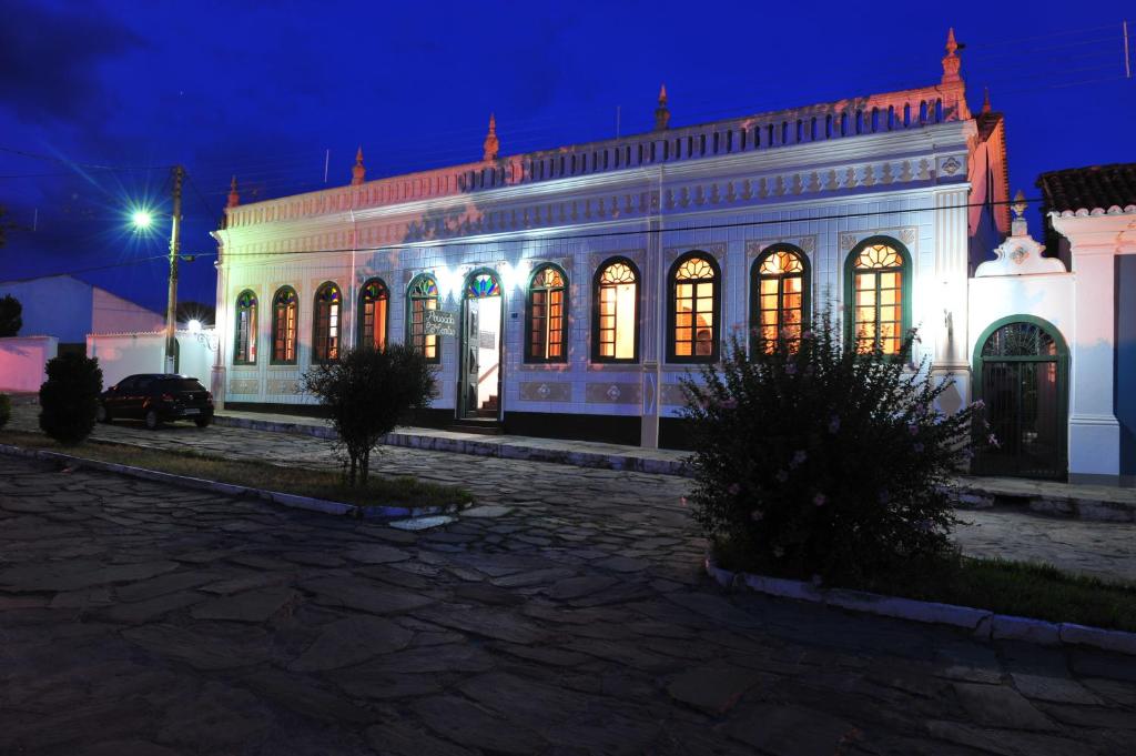 Un bâtiment blanc avec des lumières allumées la nuit dans l'établissement Pousada Rio de Contas, à Rio de Contas