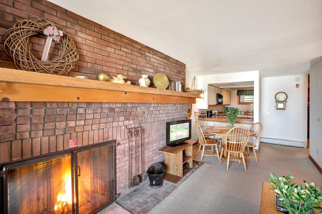 a living room with a brick wall with a fireplace at Ski on ski off, beautiful views, 2 bedroom condo with access to indoor pool, Sunrise C5 in Killington