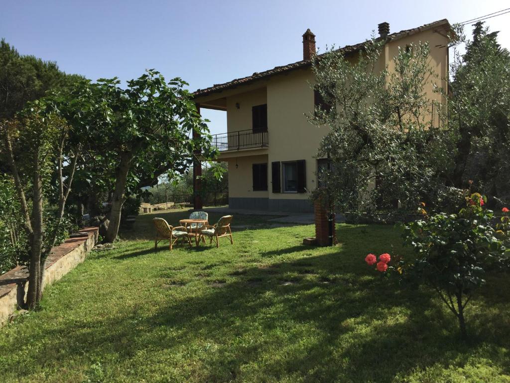 a house with a yard with a table and chairs at Casa di Vittoria in Civitella in Val di Chiana
