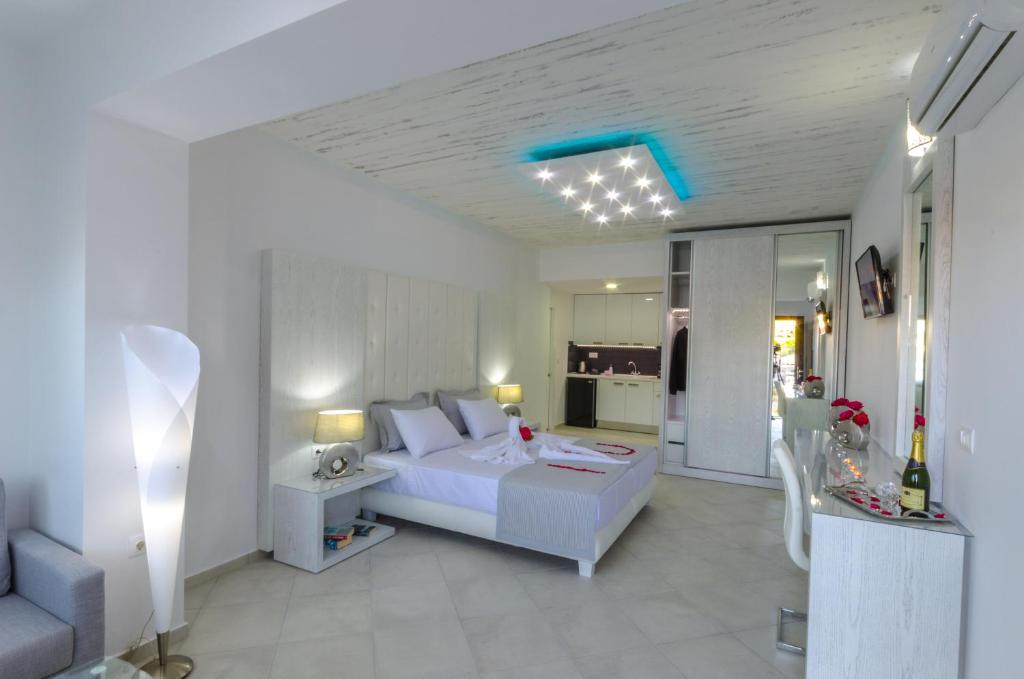 FTELIA LUXURY STUDIO ''QUATTRO'' في شاطئ ميغالي أموس: غرفة بيضاء مع سرير وغرفة معيشة