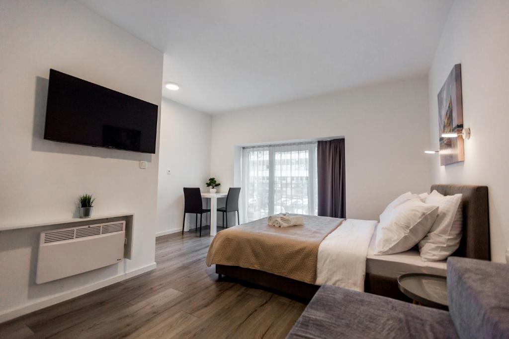 1 dormitorio con 1 cama y TV en la pared en King's Street Apartments en Zagreb