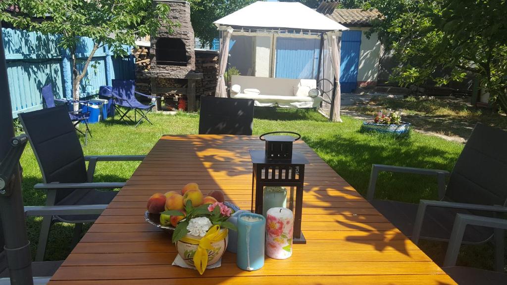 a wooden table with a bowl of fruit and a candle at Casa Bunicilor Granny's House in Jurilovca