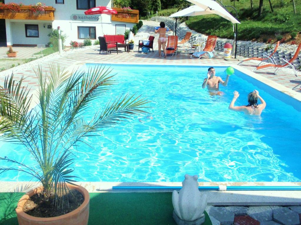 two people playing with a ball in a swimming pool at Apartment Ossiachersee Treffen in Afritz