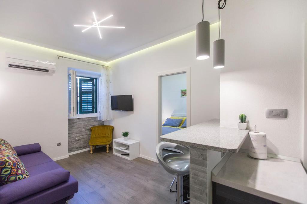 sala de estar con mesa y sofá púrpura en Centrino Apartment, en Split