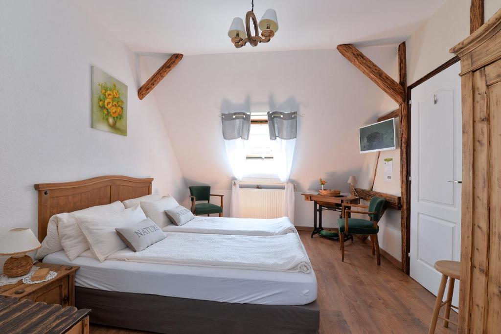 a bedroom with a bed and a desk and a window at Eden des choux in Krautergersheim