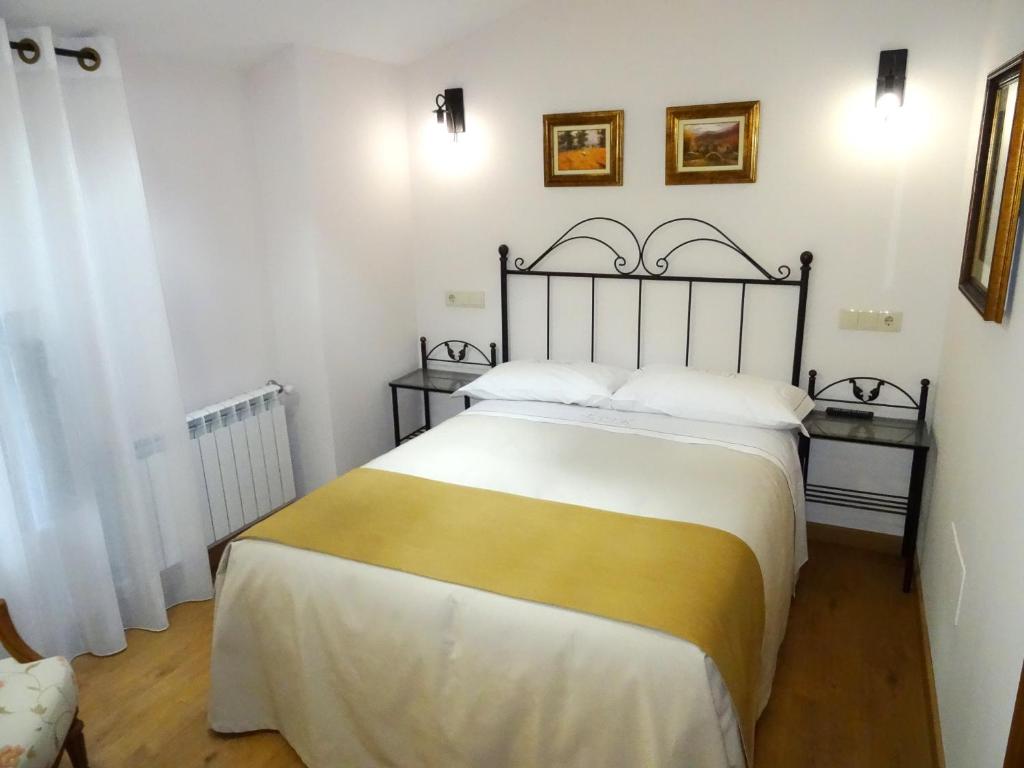 1 dormitorio con 1 cama grande con sábanas blancas y amarillas en LAST 12K, en Santiago de Compostela