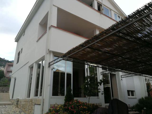 a white house with a large glass window at Guest House Mudresa in Budva
