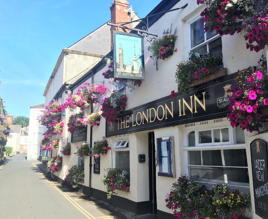 a building with flowers on it on a street at The London Inn in Padstow