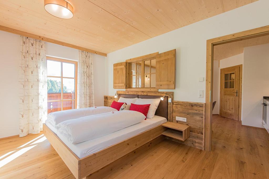 a bedroom with a large white bed with red pillows at Hinterjetzbachhof in Maria Alm am Steinernen Meer