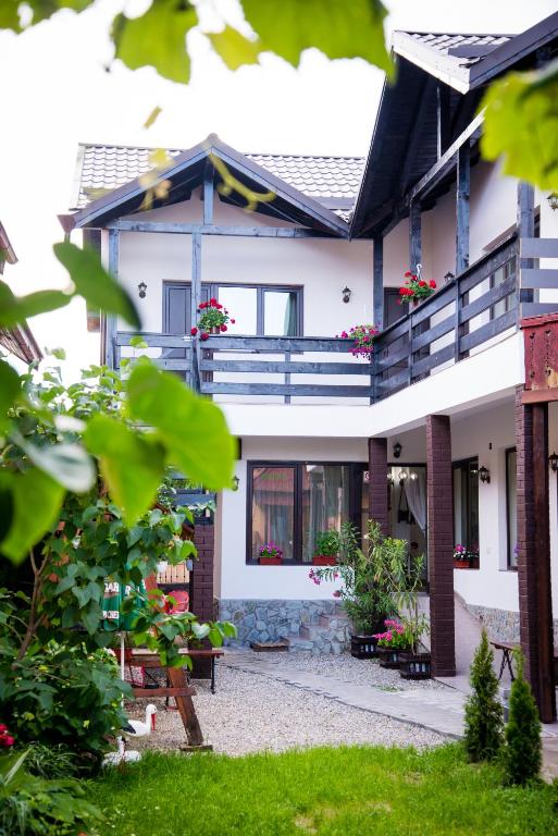 a house with a balcony and some plants at Casa de sub deal in Bîltişoara